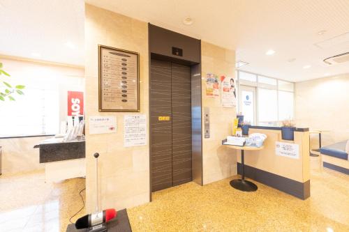 a hospital room with a door and a table at Sun Hotel Tosu Saga in Tosu