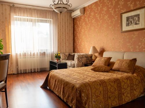 a bedroom with a bed and a couch and a window at Diplomat Club Hotel in Chişinău