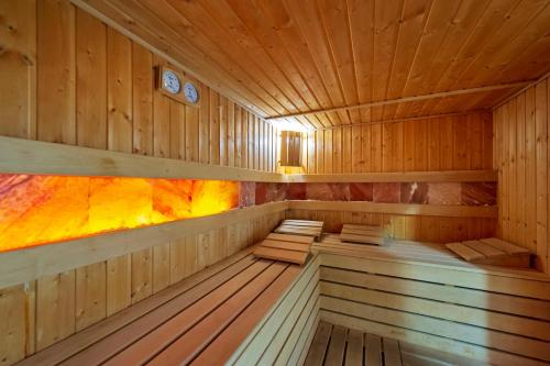a sauna with wooden walls and wooden floors and clocks at Thermal Hotel Seven Seasons in Banya
