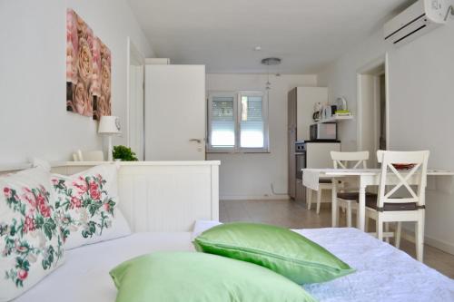 a white living room with a bed and a table at Apartmani Pax in Pakoštane