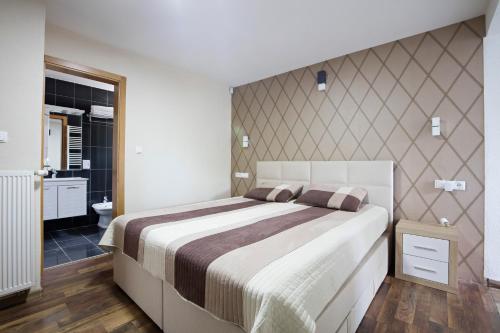 a bedroom with a large bed and a bathroom at Villa Sarajevo in Vareš