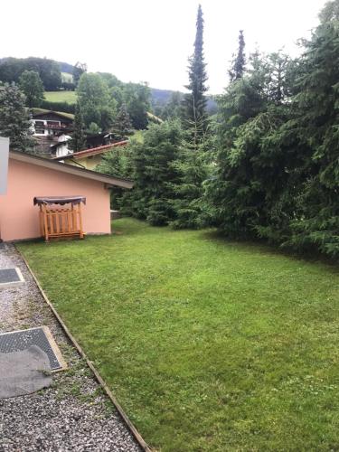 a yard with a wooden bench in the grass at Ferienwohnung Julia in Brixen im Thale