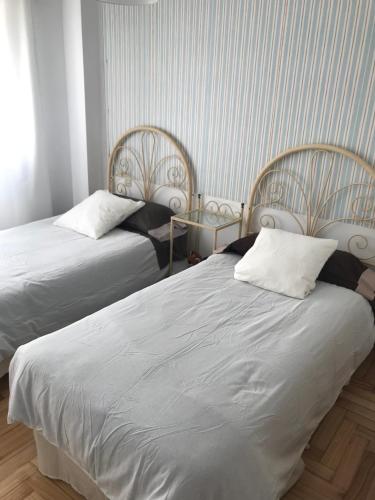 two beds sitting next to each other in a room at Urbanización loureiral in Baiona