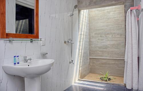 a white bathroom with a sink and a shower at Amagi Beach – Secluded Slice of Paradise in Marawila
