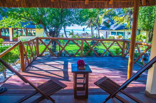 a wooden deck with two chairs and a table at Vilancool Beach Resort in Vilanculos