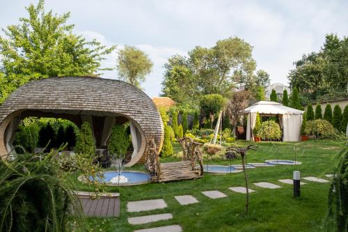 a garden with a gazebo in the grass at Diplomat Club Hotel in Chişinău