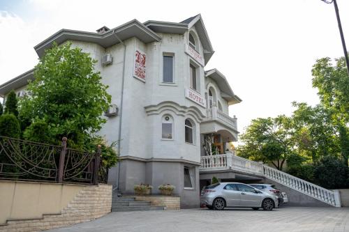 a building with a car parked in front of it at Diplomat Club Hotel in Chişinău