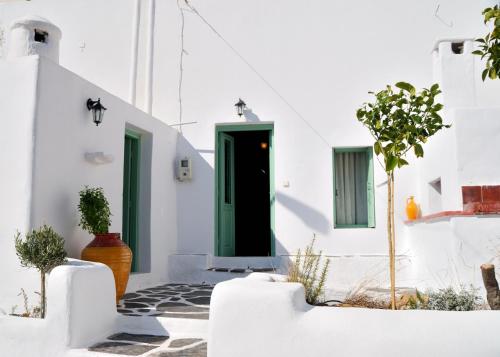 a green door in a white building with plants at Fedra's Village House in Psinthos