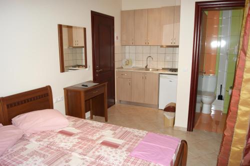 a small bedroom with a bed and a kitchen at Marie Claire Studios in Olympic Beach