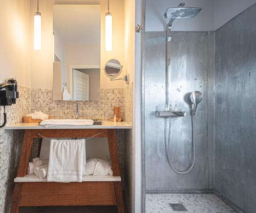 un bagno con doccia e lavandino di French Coco a La Trinité