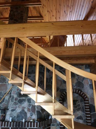 a wooden staircase in a building with a wooden ceiling at Paukoje Apartamentai in Ignalina