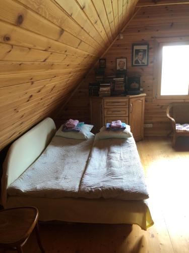 een slaapkamer met een bed in een blokhut bij Paukoje Apartamentai in Ignalina