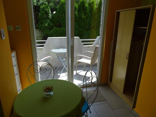 a room with a green table and chairs on a balcony at Sobe-Apartma in Maribor