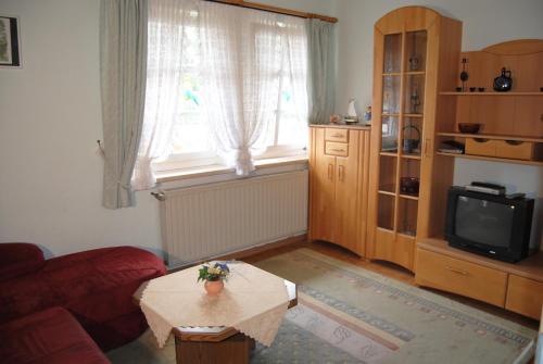 a living room with a table and a tv at Gut Dankerode in Dankerode