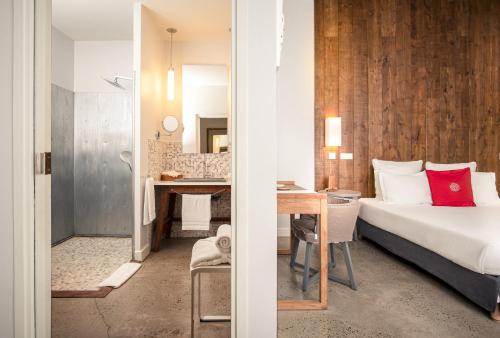 a bedroom with a bed and a desk with a table at French Coco in La Trinité