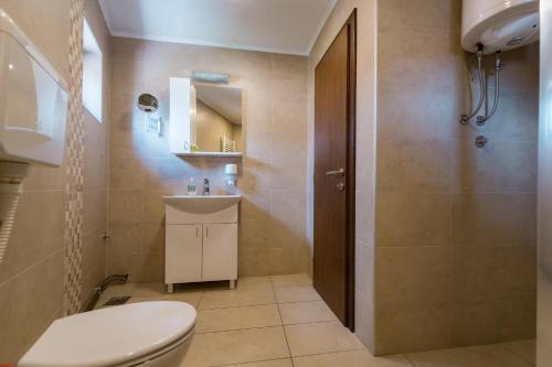 a bathroom with a toilet and a sink at Rooms Gat in Subotica