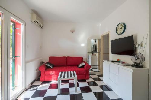 a living room with a red couch and a checkered floor at Black and White chill out in Komiža