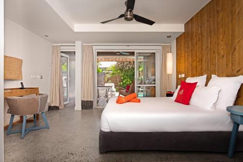 una camera da letto con un grande letto bianco con cuscini rossi di French Coco a La Trinité