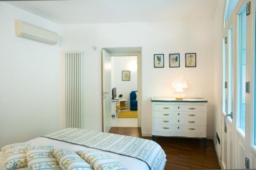 ein Schlafzimmer mit einem Bett und einer Kommode sowie ein Badezimmer in der Unterkunft BELLAGIO SUN pool near lake free parking in Bellagio