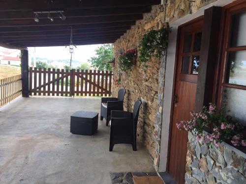 a patio with two chairs and a table and a building at Casa da Chapinheira in São Pedro de Alva