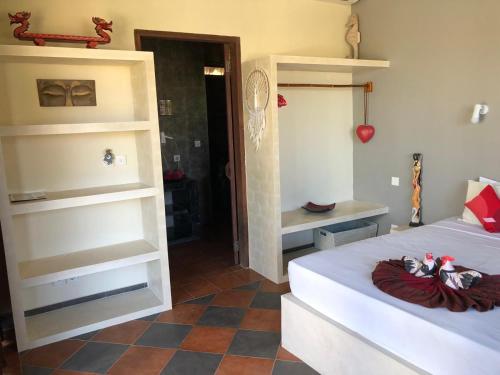 a bedroom with a bed and a room with shelves at Villa Anjing in Nusa Dua