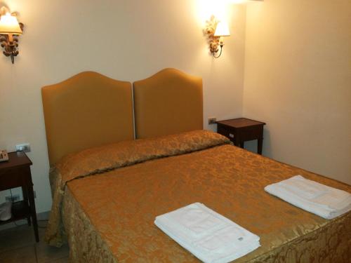 a hotel room with a bed with two towels on it at Hotel Lanzillotta in Alberobello