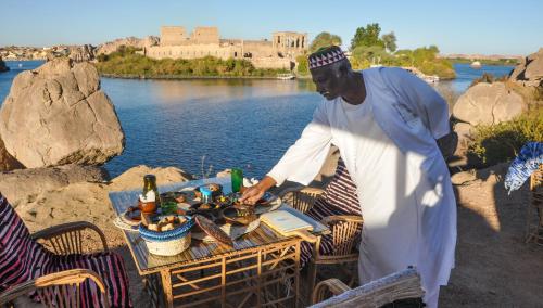 a man standing in front of a table with food at Eco Nubia in Aswan
