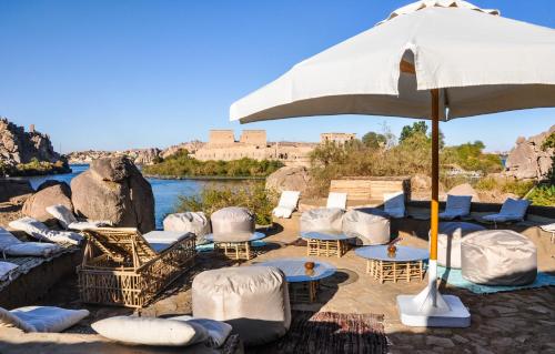a group of chairs and tables and an umbrella at Eco Nubia in Aswan
