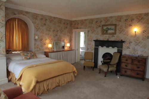 a bedroom with a large bed and a fireplace at Willowhill House Bed and Breakfast P43 YK06 in Minane Bridge