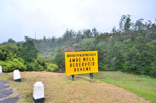 a yellow sign on the side of a road at Yensfield Blackpool in Nuwara Eliya