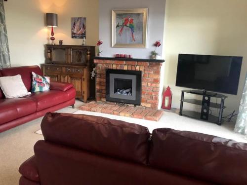 a living room with a couch and a fireplace at Lighthouse Cottage in Donegal