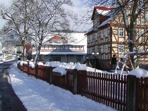 a fence in front of a house covered in snow at Gut Dankerode in Dankerode