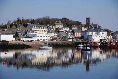 a harbor with boats in the water and a town at Lighthouse Cottage in Donegal