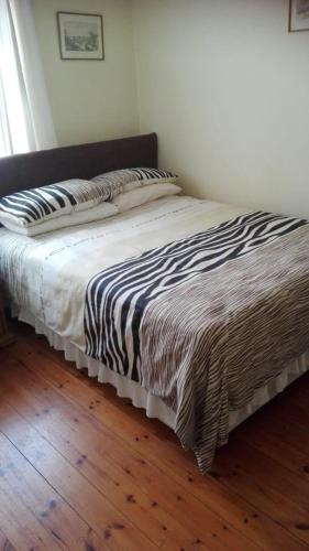 a bed with a black and white comforter in a bedroom at Isikhoma-Khoma in Hilton