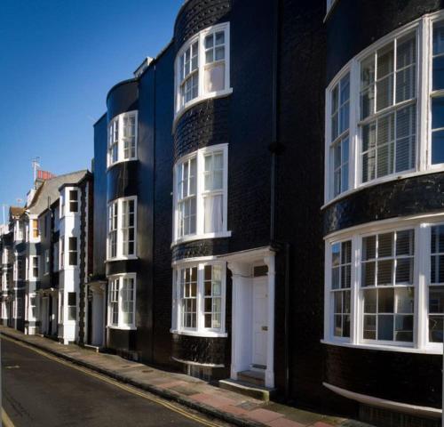 uma fila de edifícios a preto e branco numa rua em Central Brighton Town House by MyHolidayLet em Brighton & Hove