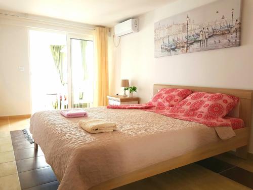 um quarto com uma cama grande e almofadas vermelhas em Boka Apartments em Tivat
