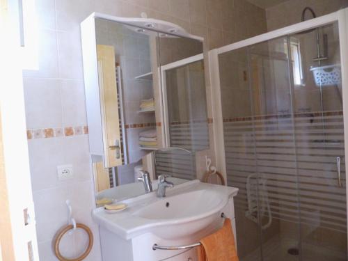 y baño blanco con lavabo y ducha. en GITE DU HOUSSAY, en Valennes