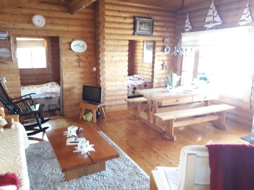 una sala de estar con una cabaña de madera con una mesa en Velkuanmaa Lomamökki, en Naantali
