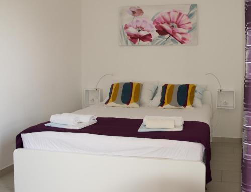 a bedroom with a white bed with two towels at Apartments Tabain in Mlini