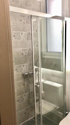 La salle de bains est pourvue d'une douche en verre et de toilettes. dans l'établissement Brand New Flat in the heart of Athens, à Athènes
