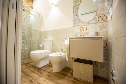 a bathroom with a toilet and a sink and a mirror at Siracusa Houses K&S in Siracusa