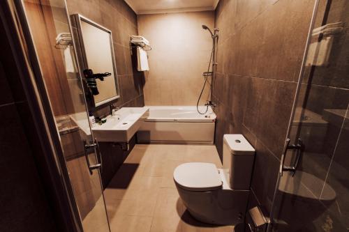 a bathroom with a toilet and a sink and a mirror at BUSINESSPALAS DELUXE in Izmit
