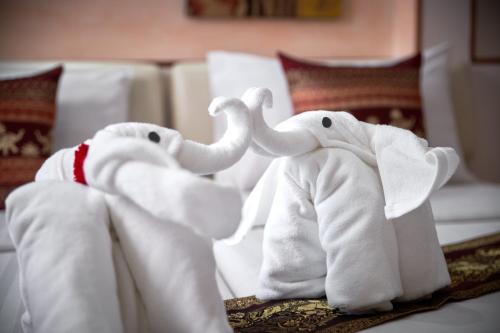 two stuffed elephants are sitting on a bed at KC Place Hotel Pratunam - SHA Extra Plus Certified in Bangkok