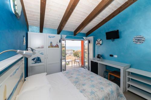 a bedroom with blue walls and a bed with a desk at Il Viaggio in Diano Marina