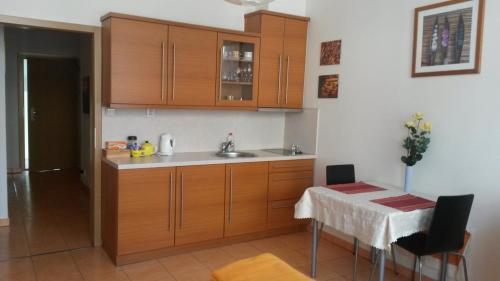 a kitchen with wooden cabinets and a table with a table cloth at Aparthotel City 5 in Prague