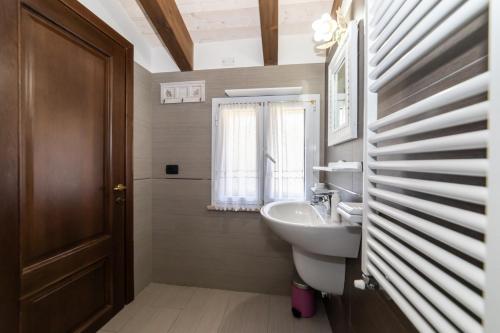a bathroom with a sink and a toilet and a window at Il Viaggio in Diano Marina
