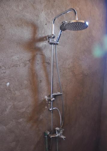 a shower head in a bathroom with a wall at Eco Nubia in Aswan