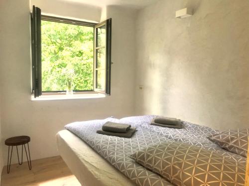 a bedroom with a bed and a window at The Little Room in Bovec