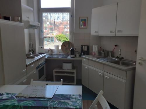 威廉港的住宿－Liberty，厨房配有白色橱柜、水槽和窗户。