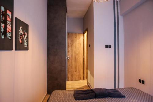 a bedroom with a bed and a wooden door at LM Luxury Central Loft in Larisa